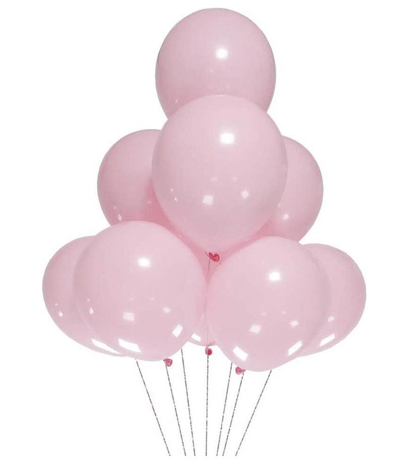 May include: A cluster of nine round, light pink balloons arranged in a pyramid shape. Each balloon has a smooth, matte finish and is attached to a thin, silver-colored string. The balloons are inflated to a uniform size and are grouped together.