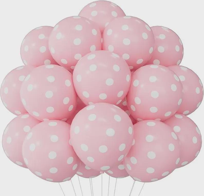 May include: A cluster of round, light pink balloons, each featuring a pattern of white polka dots. The balloons are arranged in a dense, spherical formation, with thin white strings extending downward from the base of the collection.