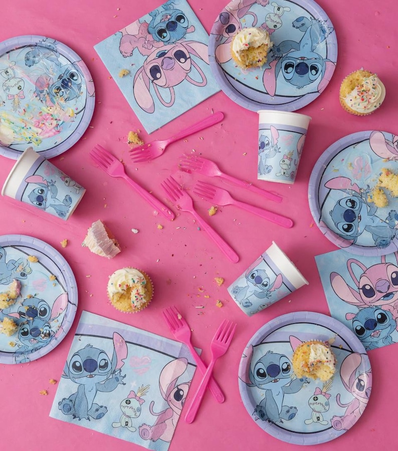 May include: A party supply set featuring Stitch and Angel from Lilo and Stitch, including light blue and purple paper plates, paper cups, napkins, and pink plastic forks, with several cupcakes scattered across the surface.