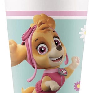 May include: A white paper cup featuring a cartoon image of Skye from Paw Patrol. The cup has a light blue background with pink and white stripes. Skye is depicted in a pink outfit with a happy expression.