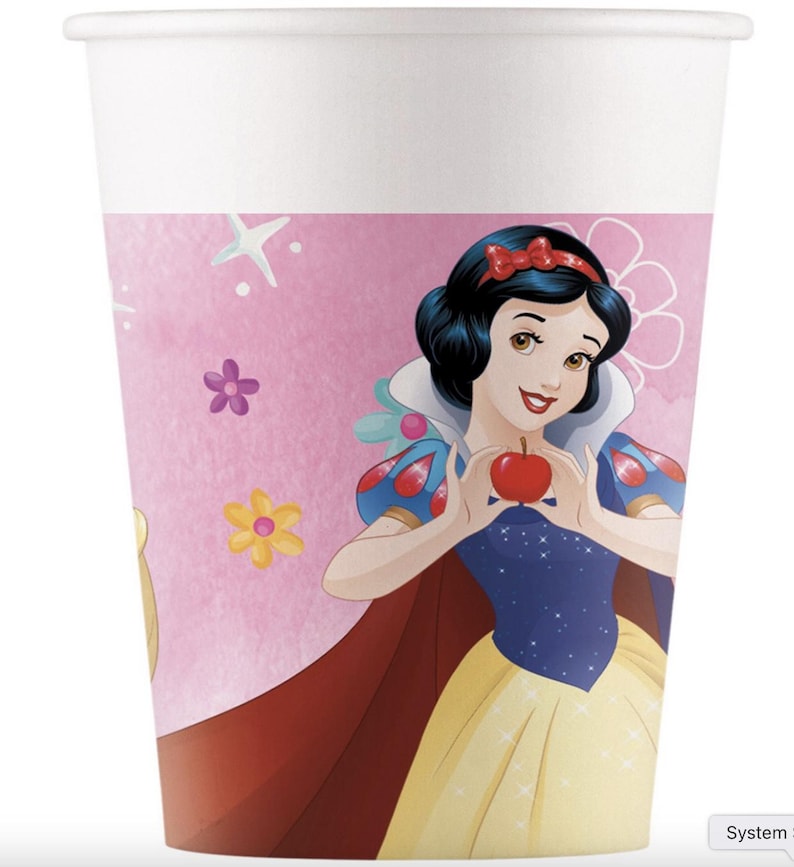 May include: A white paper cup featuring a pink band decorated with a graphic illustration of Snow White holding a red apple. The design includes small yellow and purple flowers and white star shapes against a soft pink background.