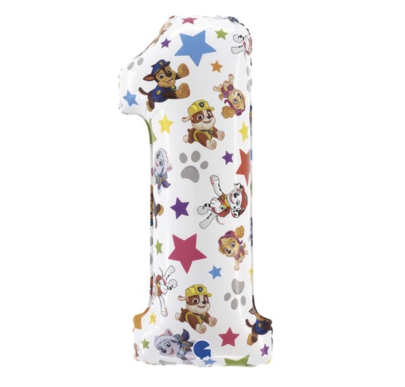 May include: A white number one balloon decorated with colorful Paw Patrol characters, stars, and paw prints. The balloon is designed for a birthday celebration.