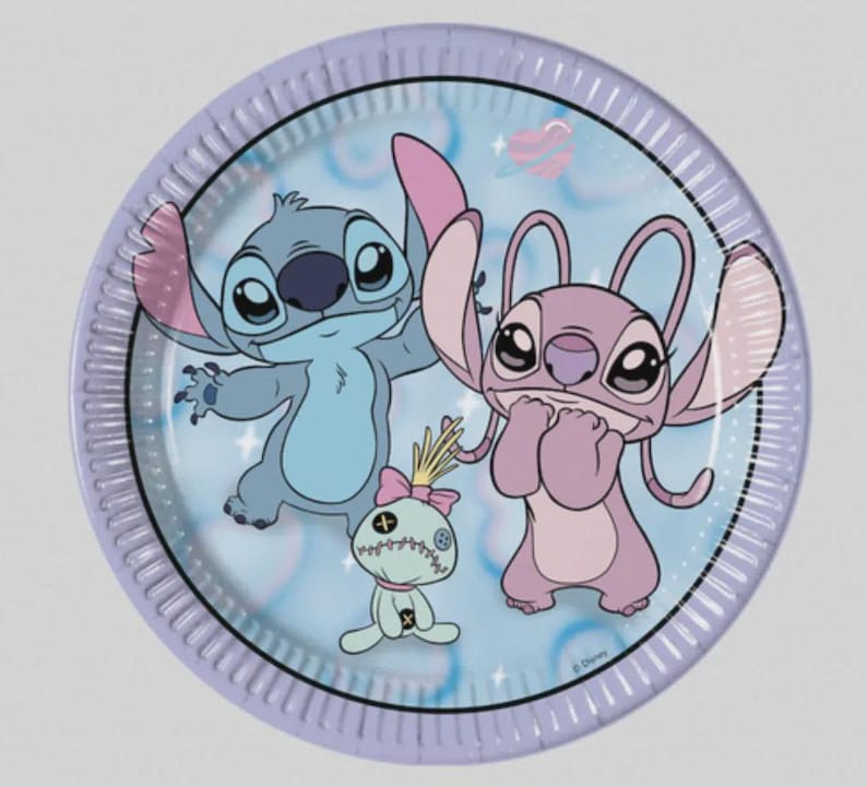 May include: A round paper plate with a light blue background featuring a graphic print of the blue character Stitch, the pink character Angel, and a small doll with a pink bow. The plate has a light purple rim and includes a small planet icon.
