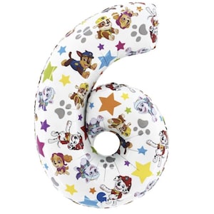 May include: White number six-shaped balloon featuring colorful Paw Patrol characters, paw prints, and stars. The balloon is designed for a birthday celebration or party. The balloon is made of a shiny, reflective material.