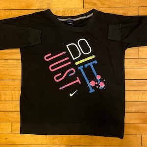 May include: Black long-sleeve sweatshirt with a white, pink, blue, and yellow graphic print that says "JUST DO IT".