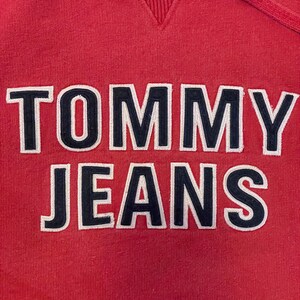 K&ouml;nnte beinhalten: Ein roter Kapuzenpullover mit dem Schriftzug "TOMMY JEANS", der in Wei&szlig; und Schwarz gestickt ist.