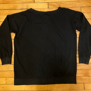 May include: A black long-sleeved sweatshirt with a crew neck.