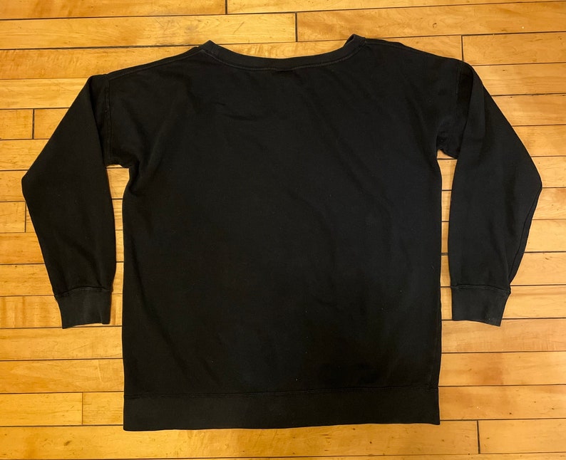 May include: A black long-sleeved sweatshirt with a crew neck.