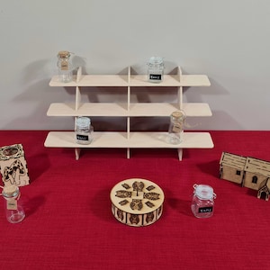 May include: A wooden shelf unit with three shelves, each with multiple compartments, displaying small glass jars with cork tops. The jars are labeled "Tami".  There are also several other wooden items on a red surface, including a small wooden box with a circular design, a small wooden church, and a small wooden box with a mushroom design.