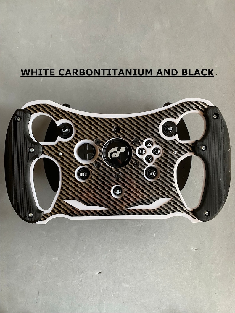 May include: A white, black, and gold racing steering wheel with a carbon fiber design. The steering wheel has buttons, a PlayStation logo, and the text "GT" in the center.