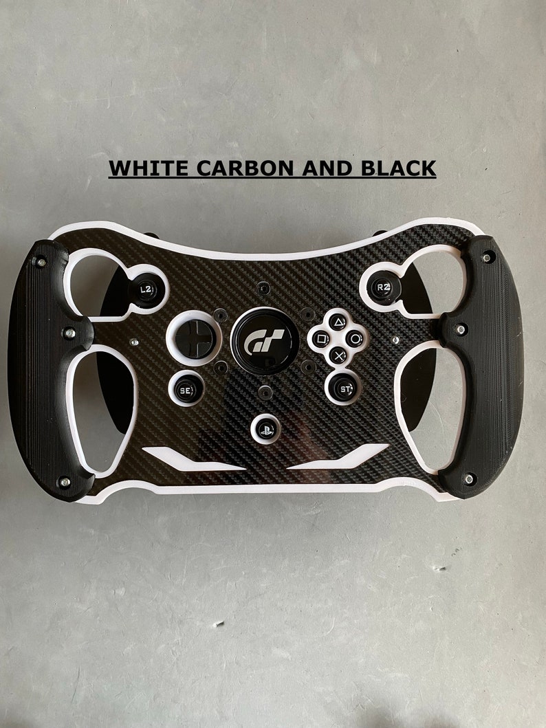 May include: A black and white racing steering wheel with a carbon fiber design and the text "GT" in the center. The steering wheel has buttons and paddles for gaming.
