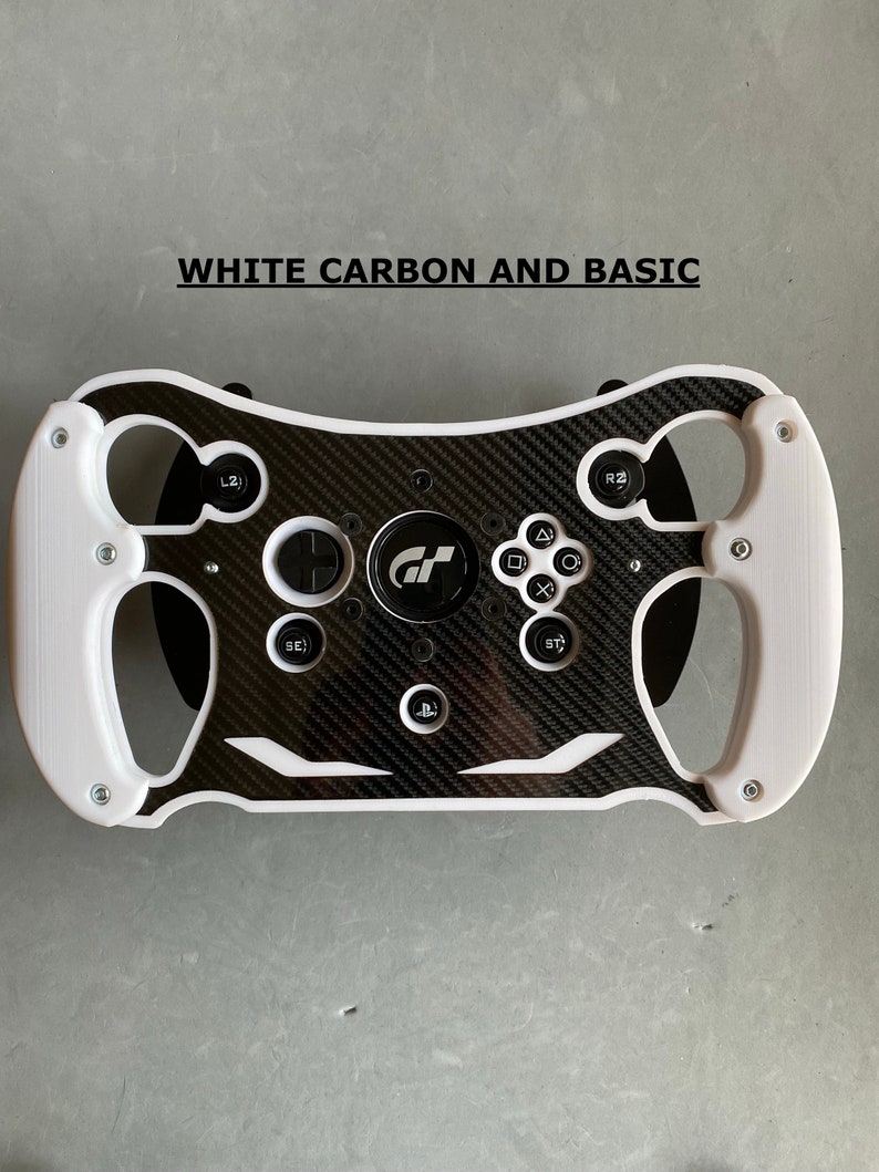 May include: White racing steering wheel with a carbon fiber design and black buttons. The steering wheel has a GT logo in the center.