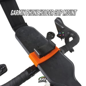 Op de afbeelding: Zwarte Garmin telefoonhouder clip mount met een oranje accent. De tekst "GARMIN PHONE HOLDER CLIP MOUNT" staat bovenaan. De mount is ontworpen om aan een fietsstuur te bevestigen. De afbeelding toont ook een fietsstuur en een bedieningspaneel.