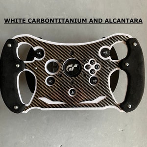 May include: White racing steering wheel with a carbon fiber and alcantara design. The steering wheel has a black suede grip and features buttons for various functions, including a PlayStation logo.