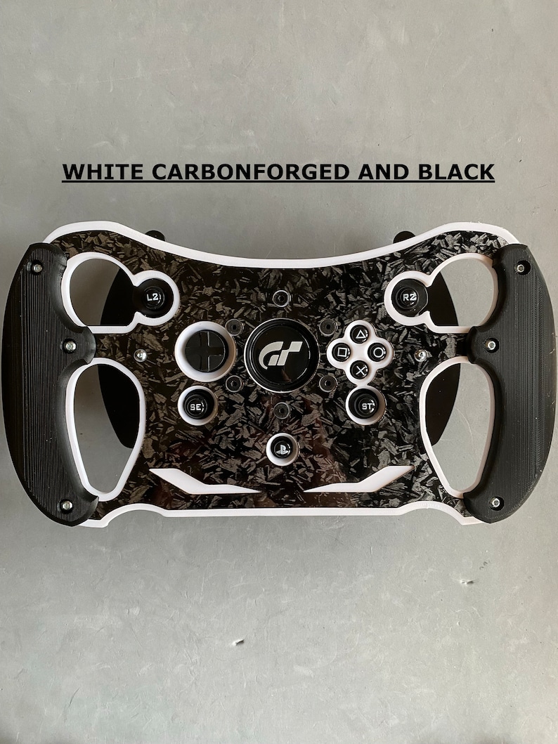 May include: A black and white racing steering wheel with a carbon fiber design. The steering wheel has a white rim and black buttons. The steering wheel has the text "WHITE CARBONFORGED AND BLACK" at the top.