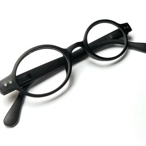 May include: Black round-framed spectacles with black arms.