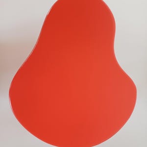 May include: A bright red, organic-shaped, abstract wall art piece.