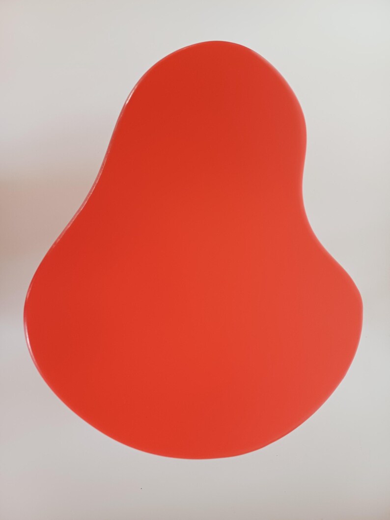 May include: A bright red, organic-shaped, abstract wall art piece.