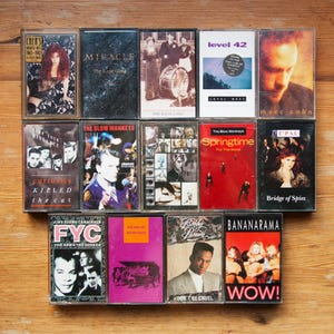 May include: A collection of 12 vintage cassette tapes featuring a range of artists and album titles. The tapes are arranged in three rows of four. The tapes are all in good condition and have a variety of colours and designs.