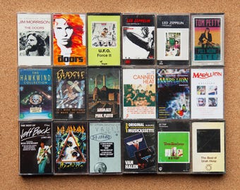 Op de afbeelding: Een verzameling vintage cassettebandjes met verschillende artiesten, waaronder Jim Morrison, The Doors, UFO, Led Zeppelin, Tom Petty, Hawkwind, Budgie, Pink Floyd, Canned Heat, Marillion, Jeff Beck, Def Leppard, Van Halen, ZZ Top en Uriah Heep.