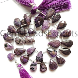 Puede incluir: Hebras de cuentas de piedras preciosas de charoíta facetadas en tonos morados, marrones y negros. Las cuentas en forma de lágrima están ensartadas en alambre de plata, con una borla morada en cada extremo. La imagen incluye el texto "GemsbeadsExperts".