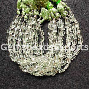 May include: Strands of light green, faceted gemstone beads with a rectangular shape. The beads are strung together and topped with green tassels. The text "GemsbeadsExports" is visible in the lower left corner.