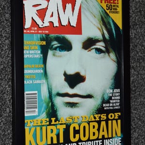 May include: A framed copy of the April 27-May 10 1994 issue of Raw magazine featuring a portrait of Kurt Cobain on the cover. The headline reads The Last Days of Kurt Cobain, with text highlighting features on Napalm Death, Soundgarden, and Black Sabbath.
