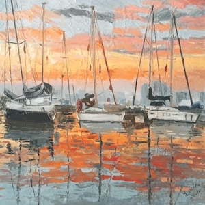 Puede incluir: Una pintura al óleo que representa tres veleros amarrados en aguas tranquilas durante el atardecer. El cielo y el agua presentan tonos vibrantes de naranja, rosa y gris con pinceladas gruesas y texturizadas. Firma visible abajo a la derecha.