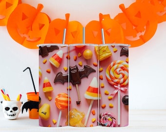 May include: Three Halloween-themed tumblers with candy and bat designs. The tumblers feature a pink background with candy corn, lollipops, and chocolate bats. Orange pumpkin cutouts and a skull-shaped container with candy complete the festive scene.