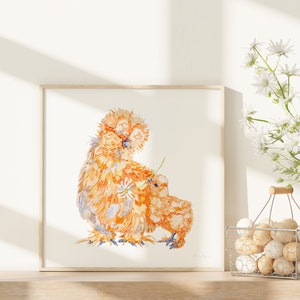 The print of the silkie chicken hen and chick has been framed, and displayed next to a basket of eggs and white daisies in a bright sunny kitchen.