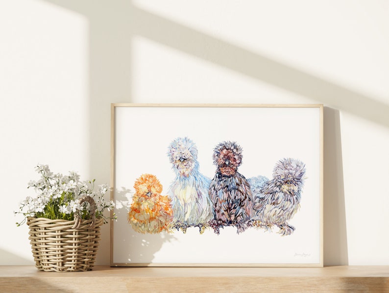 A print of four beautiful silkie chickens painted in watercolour. There are birds of four different colours sitting in a row. The print is next to a basket little white flowers.