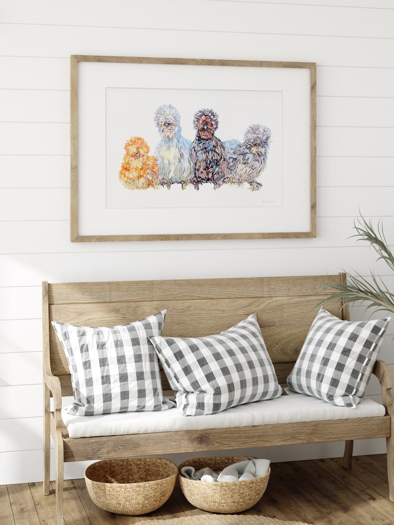 A print of four beautiful silkie chickens painted in watercolour. The illustration shows a variety of silkie colours and is framed in a sunny farmhouse entryway.