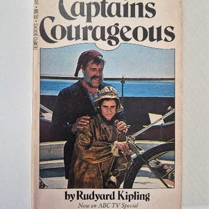 May include: Vintage paperback book titled "Captains Courageous" by Rudyard Kipling. The cover features an illustration of two people on a boat, with the title in large, stylized letters. The book is a Tempo Books edition.