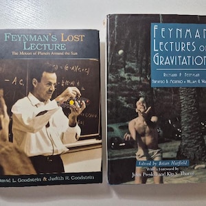 May include: Two hardcover books titled Feynman's Lost Lecture: The Motion of Planets Around the Sun and Feynman Lectures on Gravitation. The first cover shows a man in a white shirt holding a model, and the second shows a person juggling outdoors.