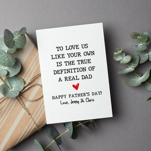 May include: A white card with black text that reads "To love us like your own is the true definition of a real dad." A red heart is drawn below the text. The card also says "Happy Father's Day! Love, Jenny & Chris".