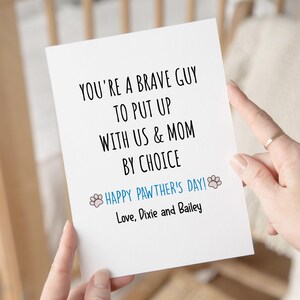 May include: A white greeting card with black text that reads "YOU'RE A BRAVE GUY TO PUT UP WITH US & MOM BY CHOICE." Below, in blue text, it says "HAPPY PAWTHER'S DAY!" and "Love, Dixie and Bailey."