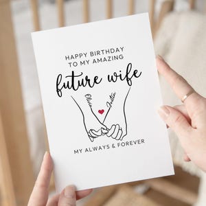 Może przedstawiać: Biała kartka z życzeniami z czarnym napisem: "Happy Birthday to my amazing future wife". Przedstawia rysunek dw&oacute;ch splecionych dłoni z imionami "Olivia" i "Justin" oraz czerwonym sercem.