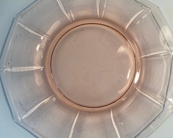 May include: A pink glass octagonal plate with a raised rim and a smooth, slightly textured surface.