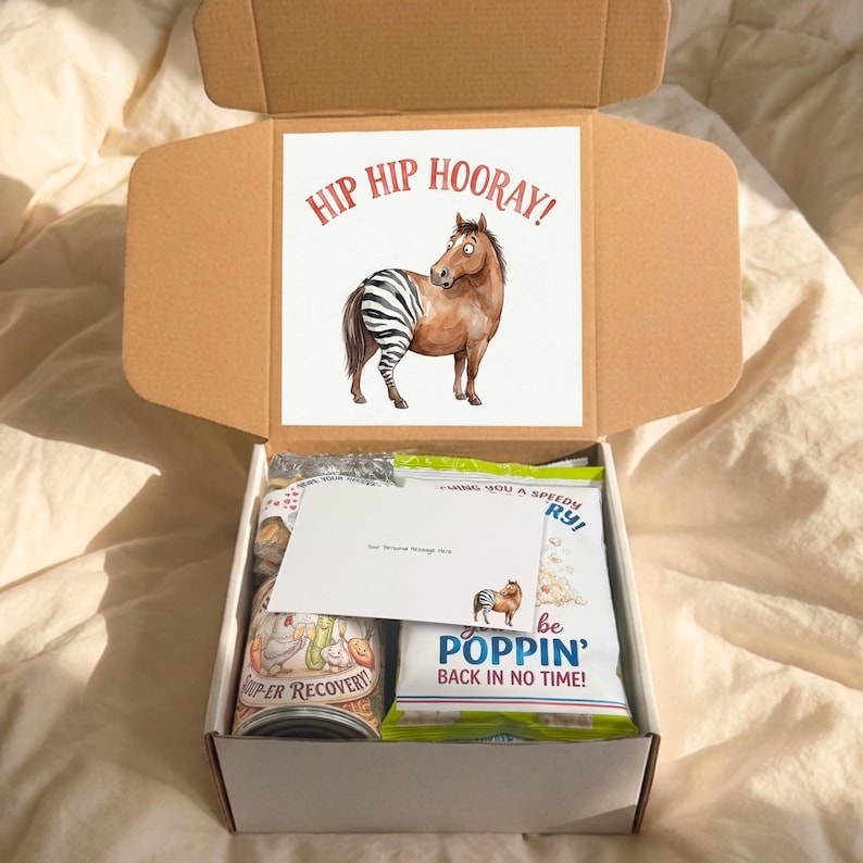 Close up view inside a funny hip surgery post-op gift box. Shows the "Hip Hip Hooray" Horse with Zebra leg sign prominent on the inside lid and packed snacks including "Toad-ally Blows" tissues and "Water You Up To" hydration packets.