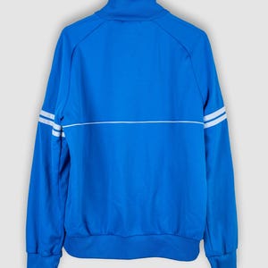 May include: A blue track jacket with white stripes on the sleeves and a white stripe across the chest.