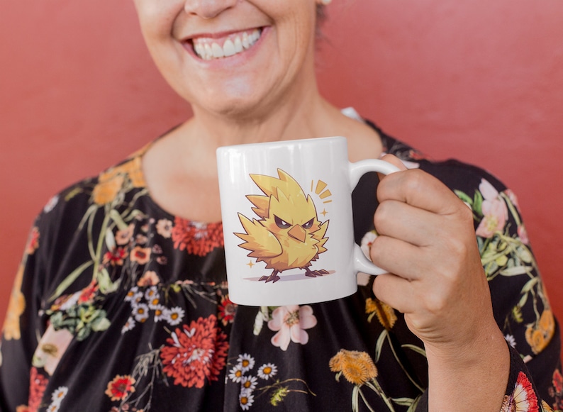 May include: A white ceramic mug with a yellow cartoon bird with a fierce expression. The bird has a yellow beak and black eyes. The mug has a black handle.
