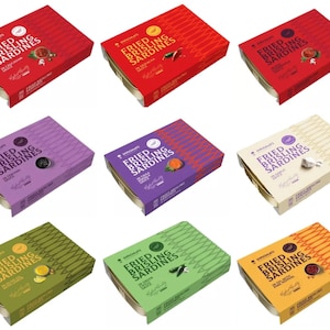 May include: Nine boxes of canned fried brisling sardines in various flavors. The boxes are rectangular with a gold-colored metal base and colorful paper tops. The text "FRIED BRISLING SARDINES" is printed on each box, along with flavor descriptions and a logo.