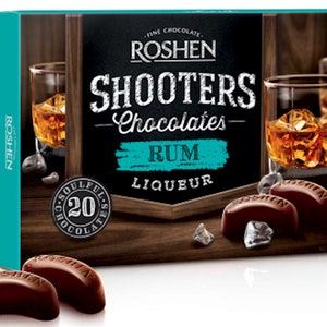 May include: A box of Roshen Shooters Chocolates with a dark blue background and a chalkboard-style design. The box features a glass of rum and the text "Shooters Chocolates - Rum Liqueur". The box contains 20 chocolates.