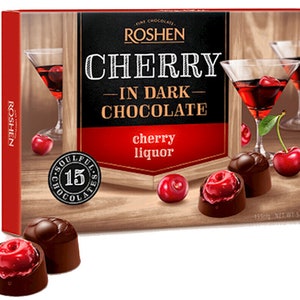 May include: A box of Roshen Cherry in Dark Chocolate candies. The box features a red background with the brand name Roshen in white text. The box also features a picture of a glass of cherry liqueur and a chocolate covered cherry. The text on the box reads "Cherry in Dark Chocolate" and "cherry liquor".