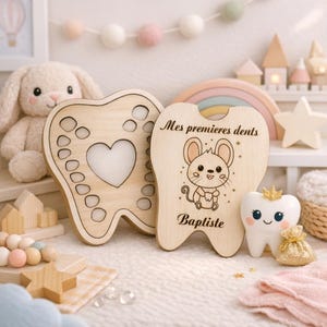 May include: Wooden tooth-shaped keepsake boxes with a heart cutout and engraved details. One box features a cute mouse illustration and the text "Mes premieres dents" and "Baptiste". A ceramic tooth with a crown and a small gold bag are also present.