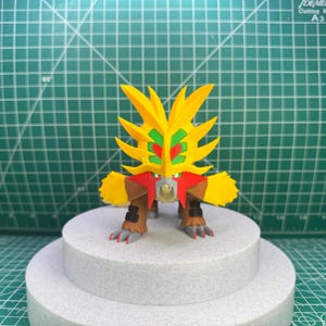 Puede incluir: Una figura impresa en 3D de un Pokémon amarillo y rojo con una melena puntiaguda y dientes afilados. La figura está de pie sobre una plataforma blanca.