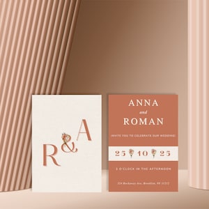 Puede incluir: Dos tarjetas de invitación de boda rectangulares. La tarjeta izquierda es crema con letras grandes en terracota R & A con un pequeño ramo floral. La tarjeta derecha es terracota con texto blanco: ANNA and ROMAN, INVITE YOU TO CELEBRATE OUR WEDDING, 25 10 25, 3 O'CLOCK IN THE AFTERNOON y 524 Rockaway Ave, Brooklyn, NY 11212.