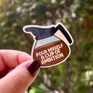 May include: A brown and white sticker of a coffee pot with the text "Pour myself a cup of ambition".