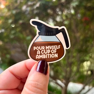 May include: A brown and white sticker of a coffee pot with the text "Pour myself a cup of ambition".