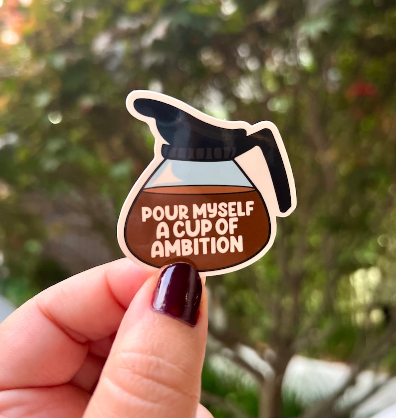 May include: A brown and white sticker of a coffee pot with the text "Pour myself a cup of ambition".
